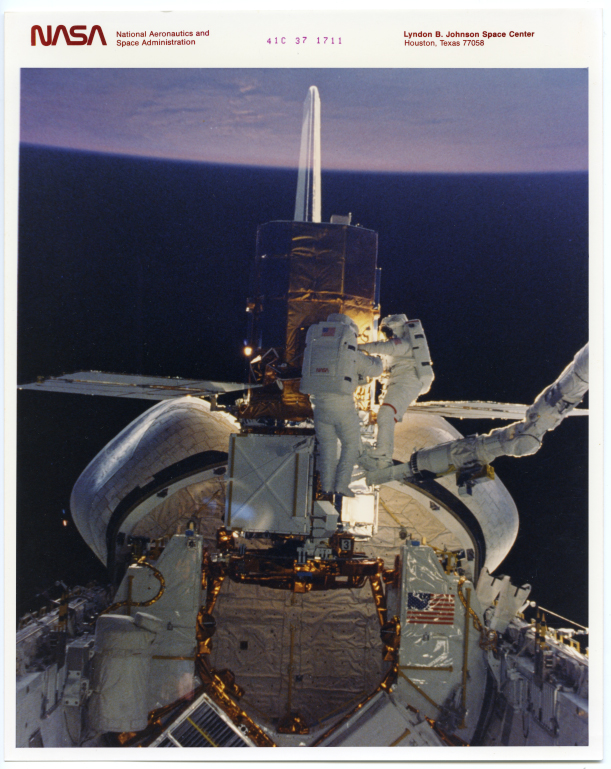 Nasa.Opération de maintenance en orbite. Navette spatiale Challenger (Mission STS-41-C). Tirage chromogénique d’époque sur papier Kodak. 25,4 x 20,3 cm