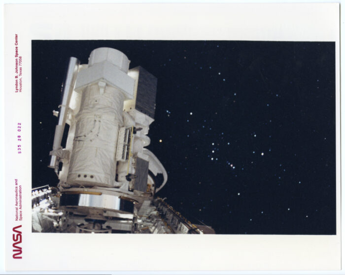 Nasa.Mise en orbite d’un télescope devant la galaxie Orion. Navette spatiale Columbia (Mission S35). Tirage chromogénique d’époque sur papier “THIS PAPER MANUFACTURED BY KODAK”. 25,4 x 20,3 cm