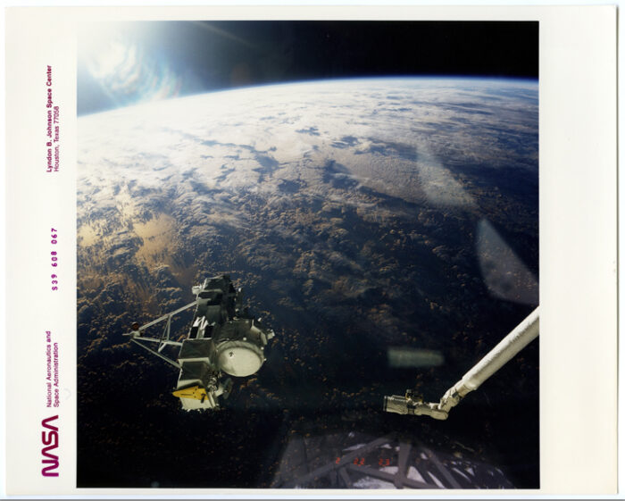 Nasa.Vue du globe terrestre et mise sur orbite d’un satellite. Navette spatiale Discovery (Misssion STS 39). Tirage chromogénique d’époque sur papier Kodak. 25,4 x 20,3 cm