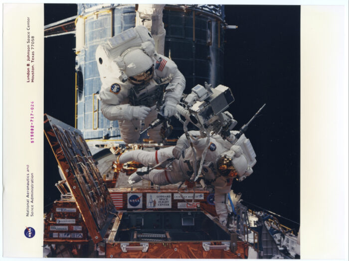 Nasa.Deux astronautes regagnent l’intérieur de la navette spatiale Discovery (Mission STS082). Tirage chromogénique d’époque sur papier Kodak. 20,3 x 27,3 cm.